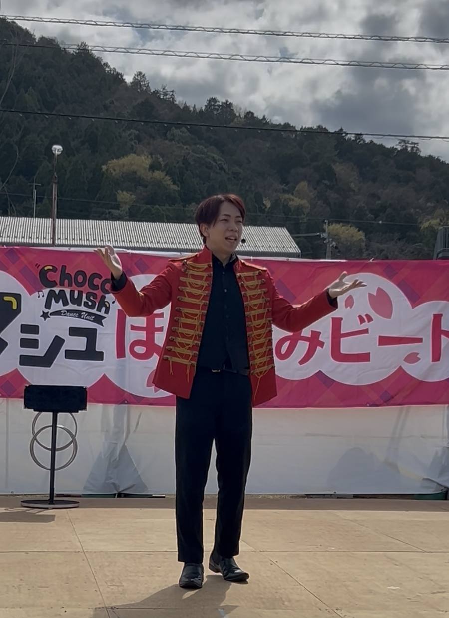 福井県おおい町の地域イベント「チョコマッシュ ほほえみビート」の野外ステージでマジックショーを披露する魔法使いクロト