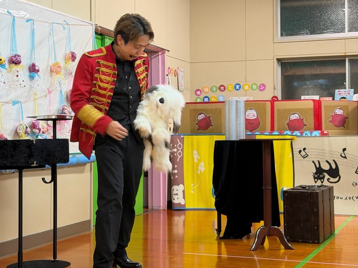 犬のパペット「マーフィー」を抱えて話しかける魔法使いクロト